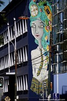 A aluna gigantesca pintou sobre um lado de edifïcio em Valparaïso, cabelo verde e cara de relógio. Chile, América do Sul.