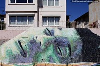 Spectacularly large mural of a person sleeping outside houses in Valparaiso.