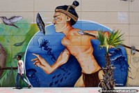 Warrior with a spear stalks the streets of Arica while trying to mingle with the public, magical street art. Chile, South America.