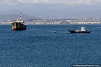 Blue waters in the bay in Coquimbo, boats and distant mountains. Chile, South America.