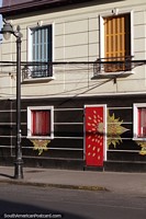 Contraventanas de madera coloridas de azul y naranja y una puerta roja en Bellavista en Santiago.