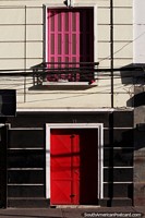 Larger version of Pink window shutters above a red door on a building facade in Bellavista in Santiago.