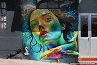 A woman and a whale, mural art painted in rainbow colors in Pelluhue.