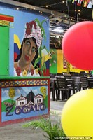 Versin ms grande de Entrada de un restaurante con globos de colores y un mural en Guatape.