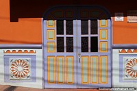 Versin ms grande de Puertas dobles moradas y naranjas con bonitos zcalos en el teatro de Guatap.