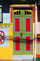 Versin ms grande de Una puerta llamativa en Guatape de rojo, verde, azul y amarillo.