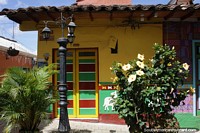 Versin ms grande de Calle pintoresca con flores amarillas y farola fuera de un edificio amarillo en Guatape.