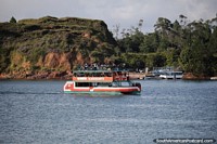 Barco de cruzeiro com pessoas sentadas no convs superior em Guatape. Colmbia, Amrica do Sul.