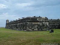 10 canhões espalham-se ao longo da parede de forte de pedra em Cartagena. Colômbia, América do Sul.