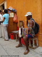 Homem que vende jóias coloridas na rua em Cartagena. Colômbia, América do Sul.