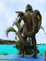 Monumento llamado Malecon de Leticia en el parque al lado del río en Leticia. Indigena con serpiente enorme. Colombia, Sudamerica.