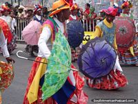 Hombres con paraguas y uso de vestidos de señoras y sombreros en Carnaval Barranquilla. Colombia, Sudamerica.