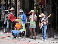 A family of buskers perform in a Bogota street. Colombia, South America.