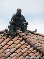 Escultura de homem que se senta em um telhado coberto com telhas em esquina de Praça Bolivar em Bogotá. Colômbia, América do Sul.