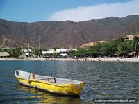 Olhar em direção a praia de Taganga com um barco amarelo no primeiro plano. Colômbia, América do Sul.