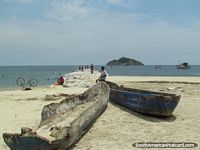 Old wooden boats and a bicycle on the beach in Santa Marta. Colombia, South America.