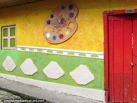 Belas cores e formas da galeria de arte em Guatape, porta vermelha e paleta de pintura com janela verde. Colômbia, América do Sul.