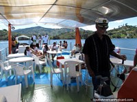 O capitão Richard que ao leme toma pessoas que viajam em volta da lagoa em Penol. Colômbia, América do Sul.