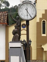 Clock-face, Bolivar statue and bust at the plaza in Salento.