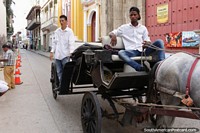 O cavalo e a carreta rolam abaixo a rua em Cartagena. Colômbia, América do Sul.