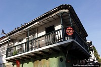 Larger version of Old wooden balcony, pigeon flies away, Cartagena.