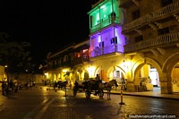 Los caballos y los carros esperan los amantes de excursiones por la ciudad en la noche en Cartagena. Colombia, Sudamerica.