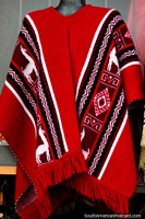 Traditional red shawl with white llamas, worn by men, for sale in Tunja. Colombia, South America.