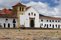 Iconic white church at Plaza Mayor in Villa de Leyva, cobblestones and tower. Colombia, South America.