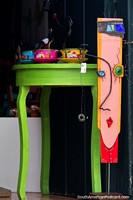 Mesa verde con cuencos de colores y una cara en un stand, tienda de arte y galería en Villa de Leyva. Colombia, Sudamerica.