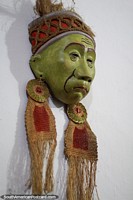 Asian man with earrings, green mask at the museum of Luis Alberto Acuna in Villa de Leyva. Colombia, South America.