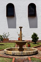 A fonte de pedra e os jardins na igreja fundam em Guatavita. Colômbia, América do Sul.
