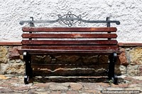 Larger version of Brown wooden bench seat on cobblestones, a good place to sit in the sun in Guatavita.