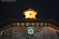 La cúpula de Guatavita brilla por la noche, la pared del primer plano tiene un dibujo religioso. Colombia, Sudamerica.