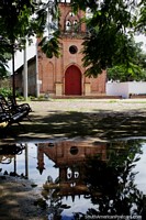 Red brick church in Ricaurte reflecting in water - Iglesia de la Inmaculada Concepcion, Girardot. Colombia, South America.