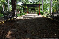 Gran parque en Ricaurte con mucha sombra, asientos y lámparas de iluminación rojas, cerca de Girardot. Colombia, Sudamerica.