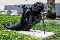 Versión más grande de La mujer toca la flauta mientras se sienta en una posición extraña en el Parque de la Música en Ibagué.