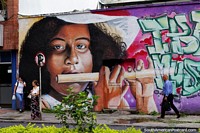 Girl plays flute, street art with musical themes all around Ibague, the music capital. Colombia, South America.