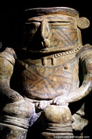 Man sitting in a seat, some of the amazing pottery you see at La Merced Archaeological Museum in Cali. Colombia, South America.