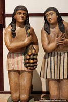 Pair of females, one with fruit at La Merced Museum of Religious Art in Cali. Colombia, South America.