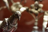 Silver bird and distant flowers, antiques at La Merced Museum of Religious Art in Cali. Colombia, South America.