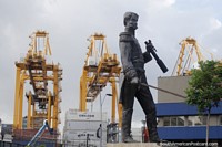Guindastes no porto e uma estátua de um homem que mantém uma espada em Buenaventura. Colômbia, América do Sul.