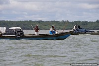 Hombres que transportan carga en barcos frente a la costa de Buenaventura. Colombia, Sudamerica.