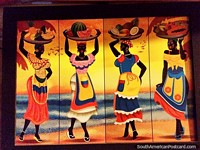 As mulheres famosas de Cartagena com vestidos vermelhos, azuis e amarelos e travessas de fruto acima das suas cabeças, que pintam em Taganga. Colômbia, América do Sul.