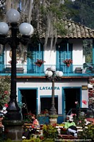 Atractivo edificio con balcón y puertas de color azul brillante, ubicado en el parque de Jardin. Colombia, Sudamerica.