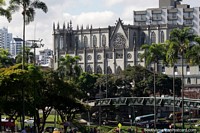 Iglesia de Nuestra Señora del Carmen junto a un parque con palmeras y puente peatonal en Pereira. Colombia, Sudamerica.