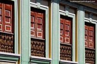 Antique wooden building with identical balconies with doors in a row in Pereira. Colombia, South America.