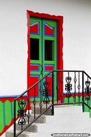A welcoming front door, very colorful with stairs and railing leading up in Salento. Colombia, South America.