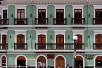 Edifício super atraente com arcos simétricos, portas e varandas acima das lojas em Pasto. Colômbia, América do Sul.