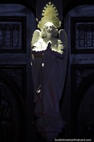 Versión más grande de Ángel en la puerta, resplandeciente de blanco en la puerta de madera de la iglesia de Las Lajas.