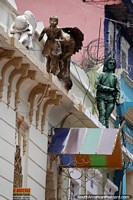 2 figuras estão nos telhados acima da rua em La Candelaria, em Bogotá, observe de perto, há uma terceira. Colômbia, América do Sul.
